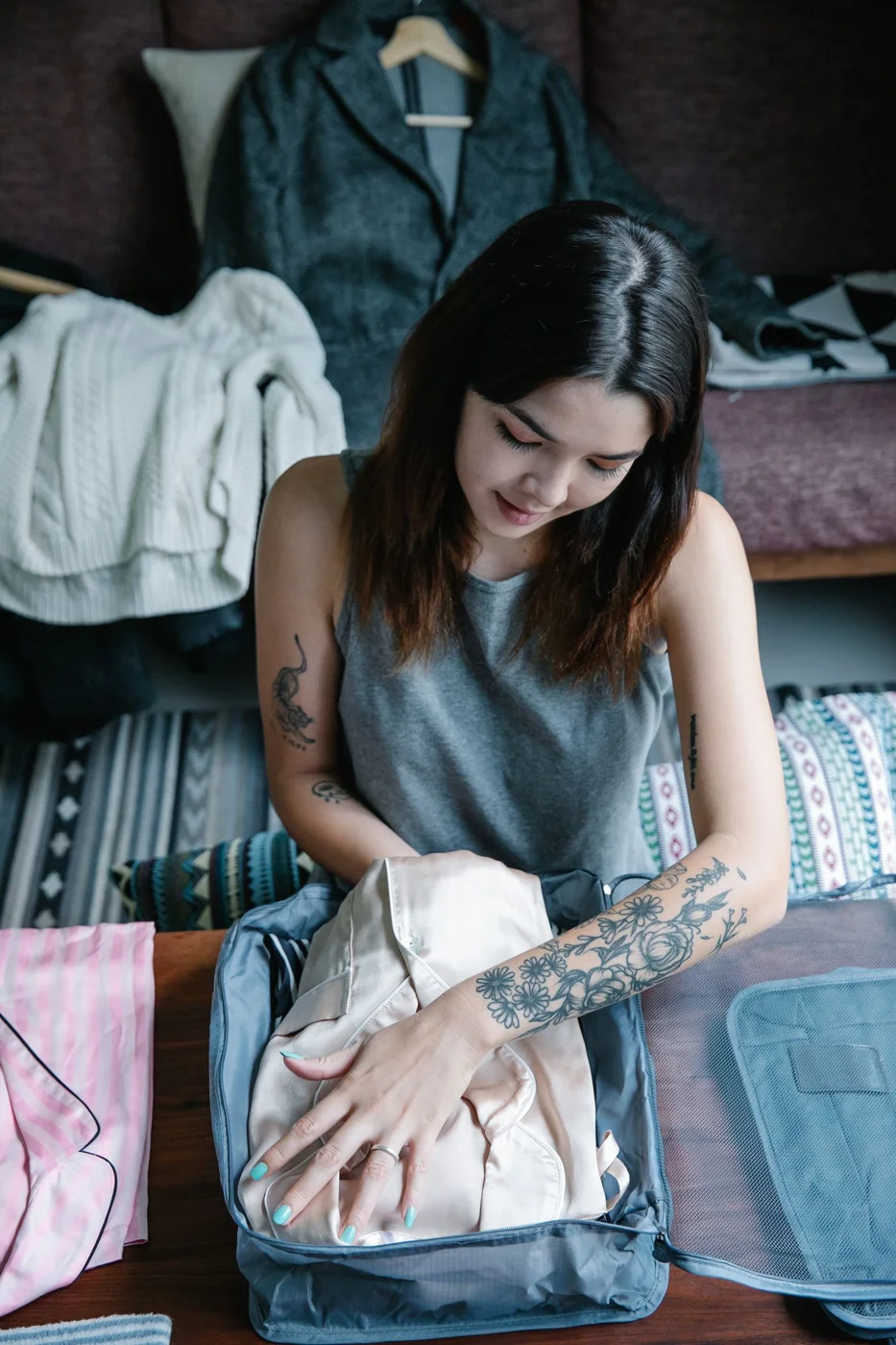 A traveler arranging clothing in an open travel bag