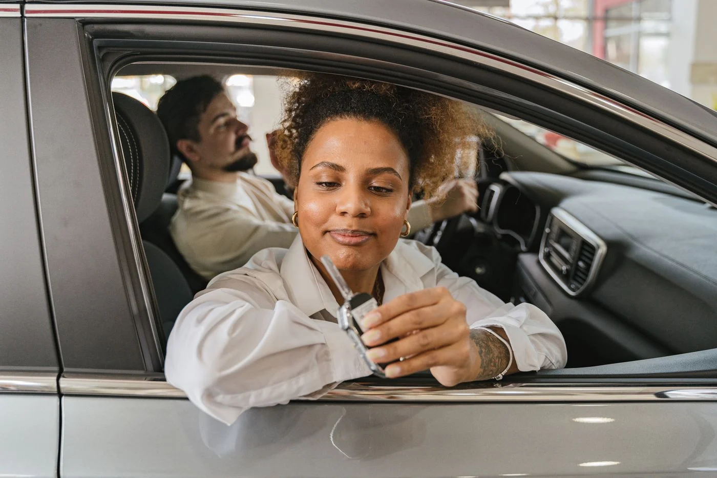 Two people in a car with a key held ready for the journey