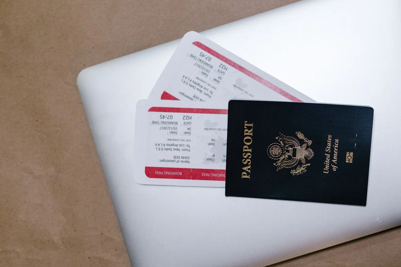 Travel tickets and a passport arranged on a laptop